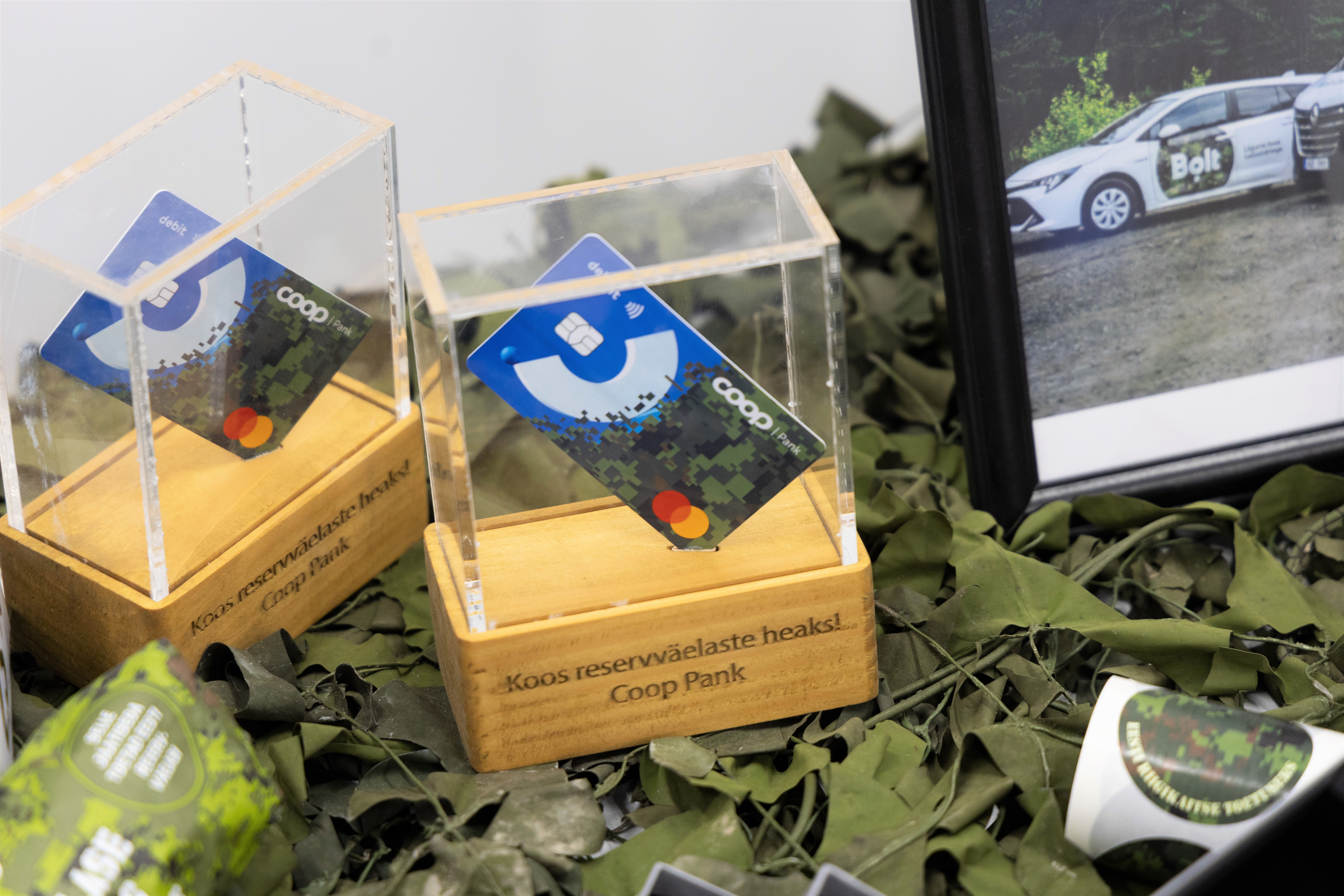 Coop Panga Kaardiväe disainiga pangakaardid klaaskarpides, millel kiri „Koos reservväelaste heaks! Coop Pank“.