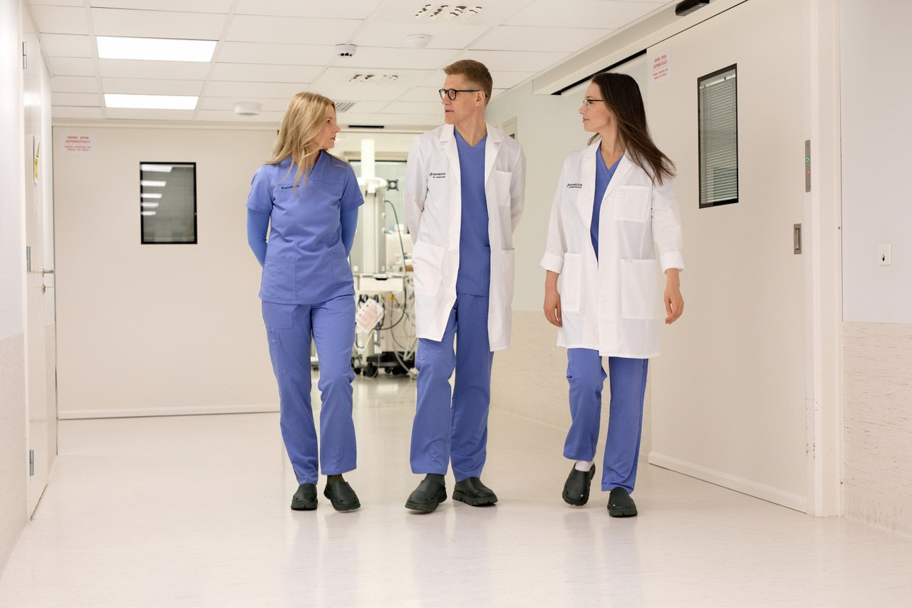 Seirekliiniku arstid ja meditsiinitöötaja kõndimas kliiniku koridoris.