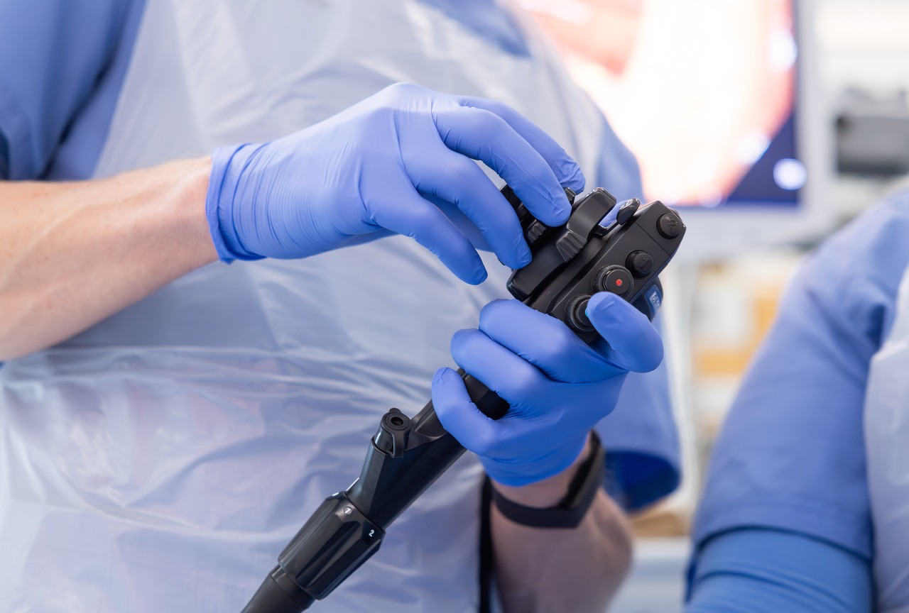 Arsti käed hoidmas endoskoopi meditsiinilise uuringu ajal.