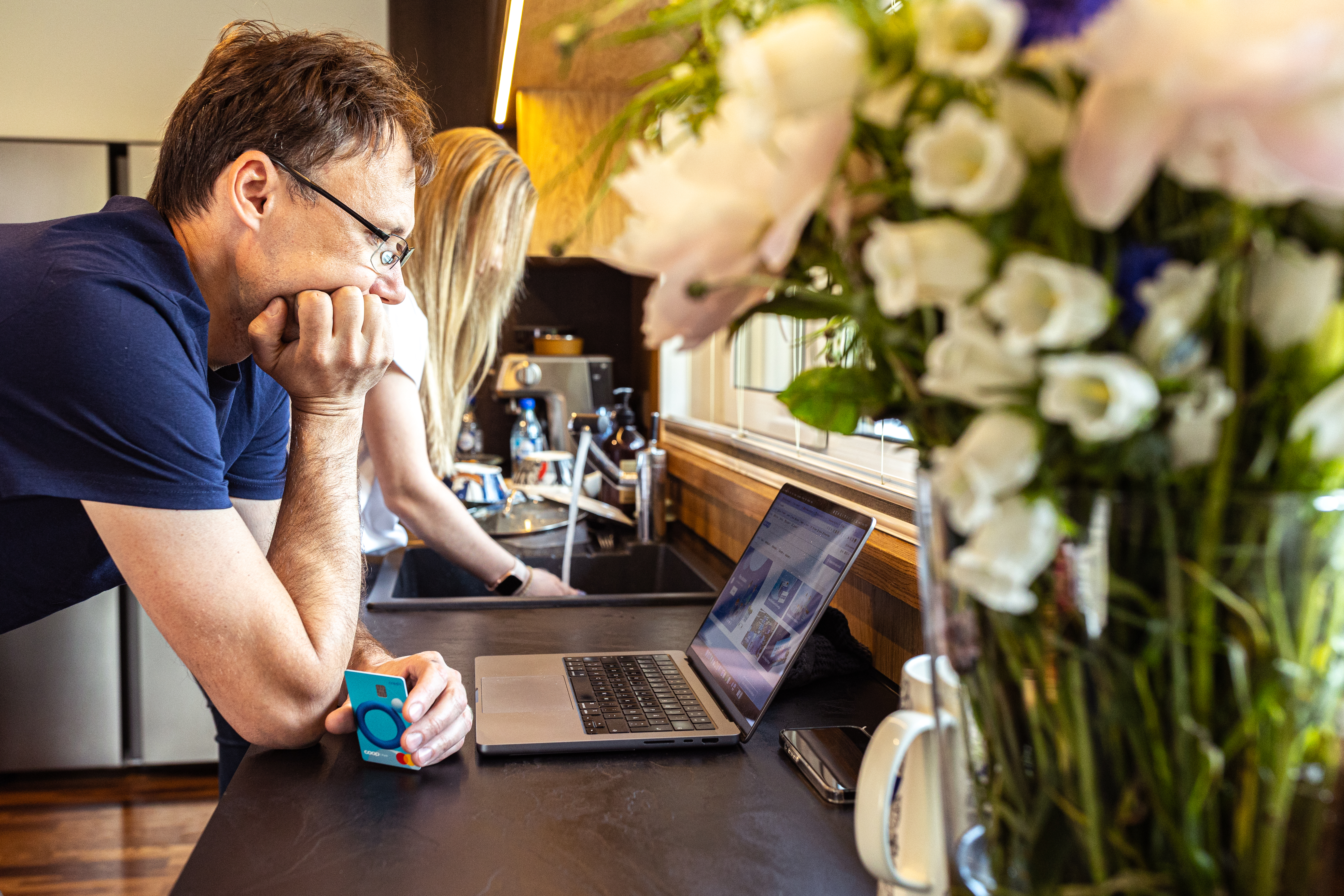 Mees ja naine vaatavad köögis sülearvutist infot ning pööravad tähelepanu veebiturvalisusele.